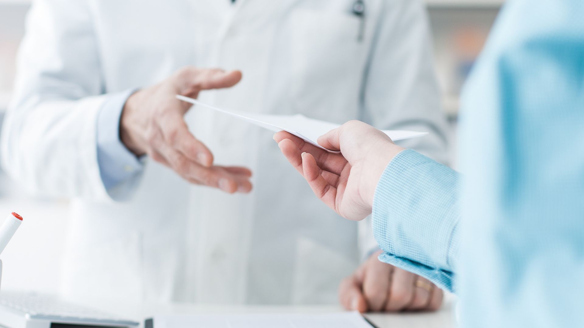 Photo of woman handing prescription to pharmacist