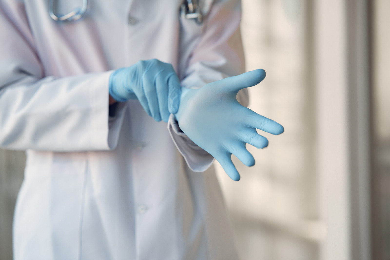 Medical professional donning gloves