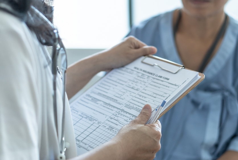 Image of a doctor reviewing documents on a clipboard