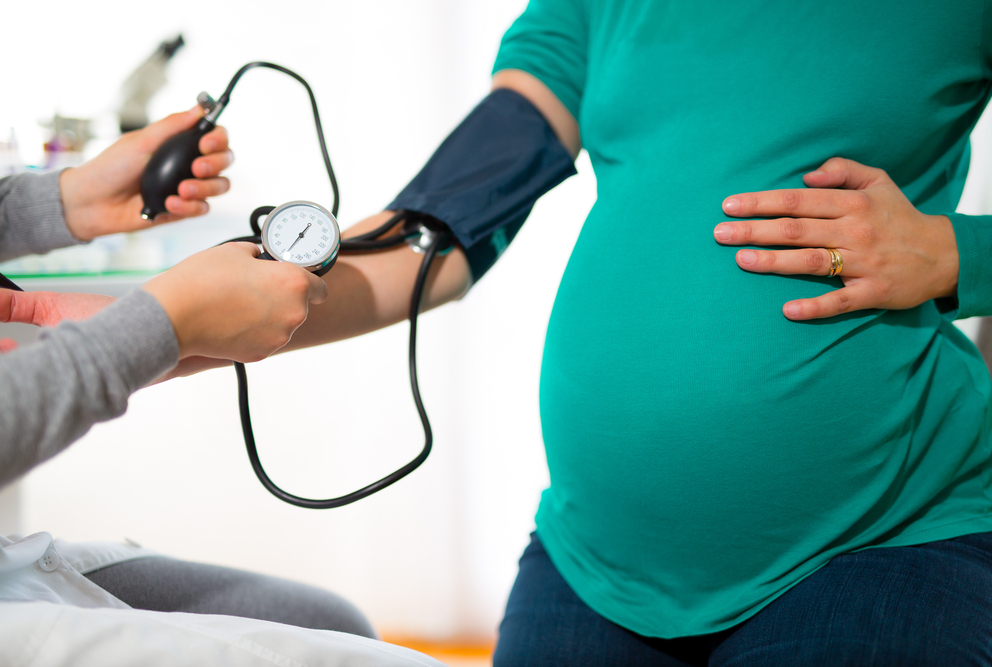 Image of pregnant woman with blood pressure cuff