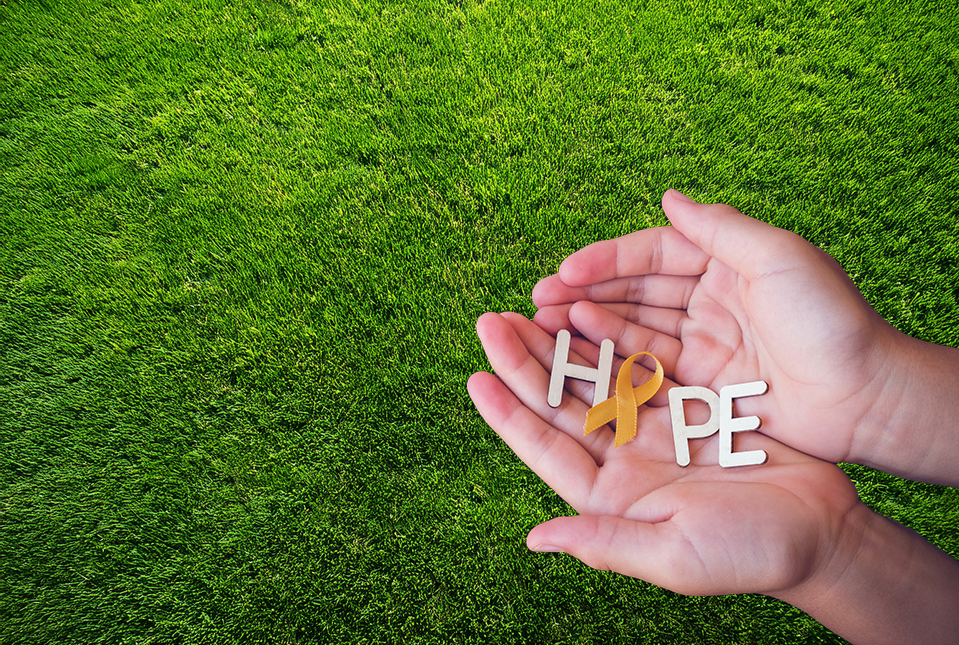 Photo of hands holding letters that spell the word "Hope." The "O" in "Hope" is a mental health awareness ribbon. 