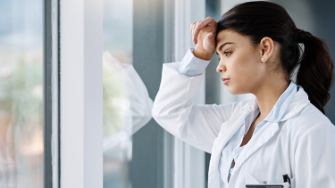 Photo of a physician looking out a windwo