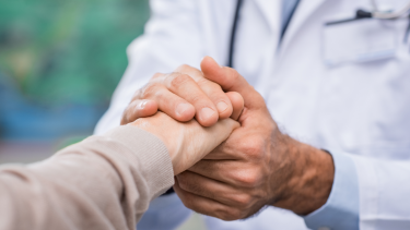 Image of physician holding patient hand