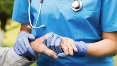Nursing home medical worker holding hand of resident