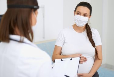 Image of a pregnant individual at a doctors appointment.