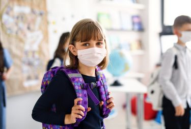Image of young girl wearing face mask at school