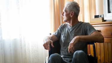 Man sitting in a wheel chair in a nursing home.